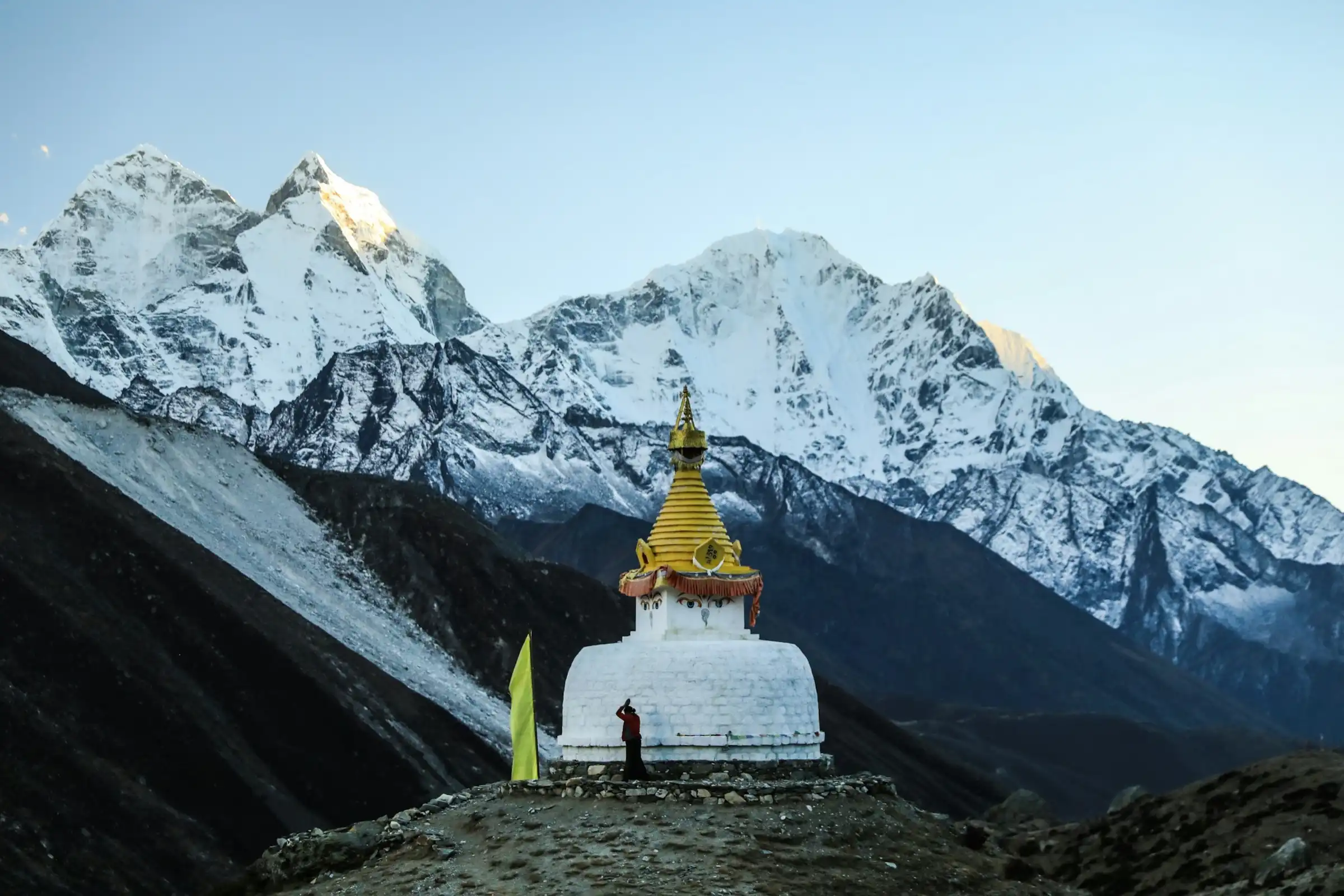 A white stupa with a gilded spire on a ridge near Dingboche, with snow peaks behind